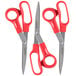 A close-up of two Universal stainless steel scissors with red bent handles.