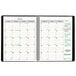 A Brownline black and green spiral-bound monthly planner with white numbers and a white cover.