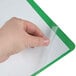 A hand using a Universal green leatherette report cover with clear plastic sheet