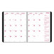 A white spiral bound calendar with red and black text on the cover.