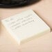 A Universal yellow sticky note pad on a counter.