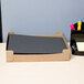 A box of Universal black paper folders on a desk with papers and pens.