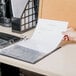 A hand using a Universal clear sheet protector to put a paper in a binder.