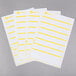 A group of white Avery file folder labels with yellow lines on a few labels.