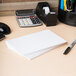 A stack of Universal white index cards on a wood surface.
