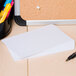 A table with a stack of Universal white ruled index cards on top.