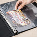 A hand inserting a photo into an Avery 3-hole punched sheet protector.