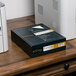 A white Southworth business paper box with a black label on a desk next to a black box.