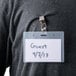 A person holding a Universal deluxe clip-on name badge holder with a name tag that says "Guest"