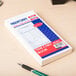 A white Rediform time card book with blue and red design on the cover.