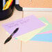 A group of Universal assorted color ruled index cards with a pen on a table.