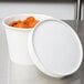 A white Double Poly-Paper soup container with a white lid on top.