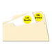 A file folder with round neon yellow Avery labels with black text on a white surface.