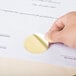 A hand holding a piece of paper with a gold Avery notarial seal.