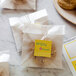 A close-up of a cookie in a plastic bag with a white square label on it.