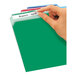 A hand holding a green file folder labeled with a green Avery Removable File Folder Label.