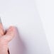 A person's hand holding a blank white Avery Printable Postcard.