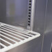 A close-up of a Turbo Air M3 Series undercounter refrigerator shelf with metal racks.