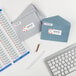 A white table with a keyboard, envelopes, and Avery Easy Peel return address labels.