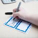 A hand using a pen to write on an Avery name badge.