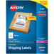 A package of 100 sheets of white Avery shipping labels with a cardboard box with a sticker.