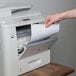 A hand putting Avery White Easy Peel Mailing Address Labels into a printer.