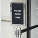 A white vertical sign frame with a black ribbon attached to it.