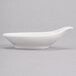 A white Royal Rideau porcelain bowl with a curved handle and a spoon on top.