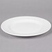 A white Reserve by Libbey porcelain plate with a wide rim on a gray surface.