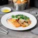 A plate of food with a fork and knife on a white Royal Rideau wide rim porcelain plate.