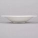 A white Reserve by Libbey Silk porcelain coupe bowl on a gray surface.