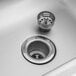 A close-up of a sink with a metal drain and stopper.