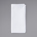 A folded white Intedge cloth napkin on a gray surface.