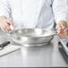 A chef preparing a French omelet in a Vollrath French omelet pan.