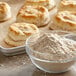 A bowl of Regal Atta Wheat Flour next to biscuits on a table.