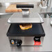 A grilled sandwich cooking in a Vollrath Cayenne Panini Press.