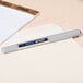 A Uni-Ball Vision pen on a desk with a note pad.