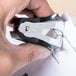 A person using a Swingline black jaw-style staple remover.