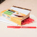 A white box of Bic red round stic ballpoint pens sitting on a notebook.