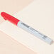 A red Universal permanent marker on a piece of paper.