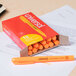 A box of Universal Fluorescent Orange Chisel Tip Highlighters on a table.
