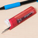A close up of a Paper Mate pen with a white cap and red accents.