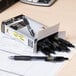 A box of Pilot G2 black rollerball pens on a table.