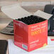 A box of Universal black chisel tip permanent markers on a desk.