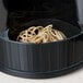 A black container with a beige Universal rubber band on a counter.