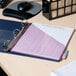 A navy blue Avery Heavy-Duty View Binder on a desk with a purple and pink paper pad.