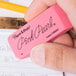 A hand holding a Paper Mate Pink Pearl eraser.