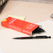 A red box of Universal Smoke Barrel Mechanical Pencils on a desk.