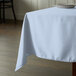 A square table with a light blue Intedge tablecloth on it.