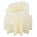 A close-up of a white plastic gear with a small hole in the center.
